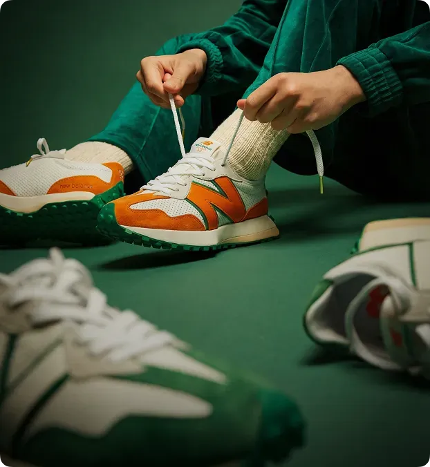 Person tying orange New Balance sneakers